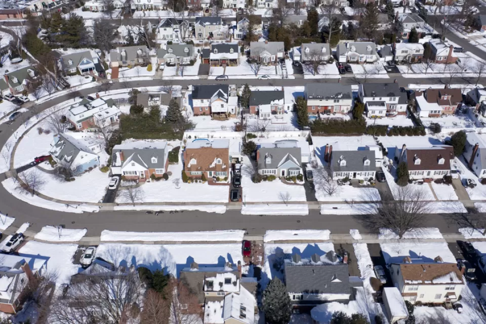 Aerial view of snowy single-family homes in suburban Long Island, New York